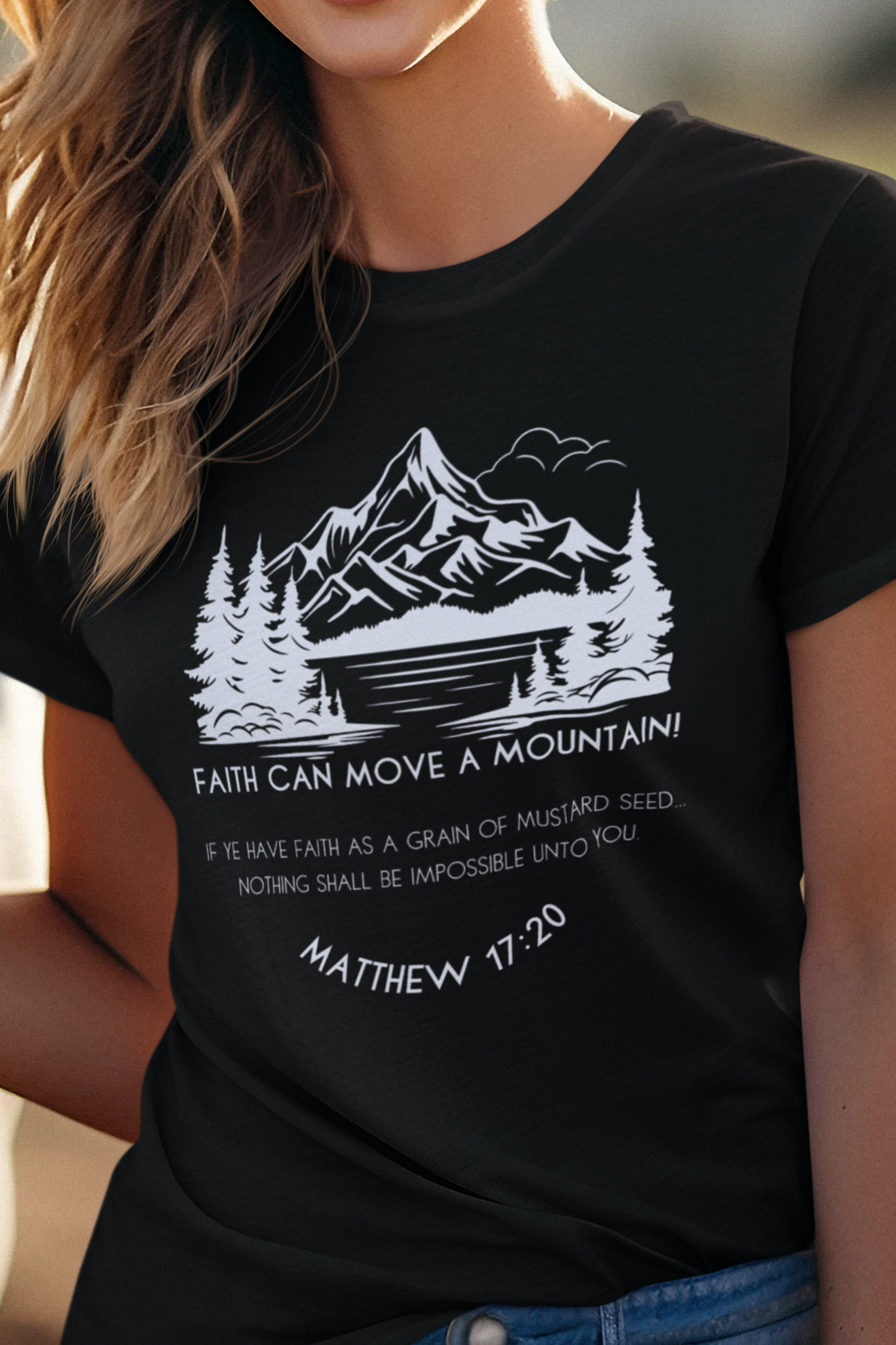 Black Christian T-Shirt for Ladies with "Faith can move a mountain. Matthew 17:20" print design. T-shirt is crew neck, short-sleeved and a classic fit.