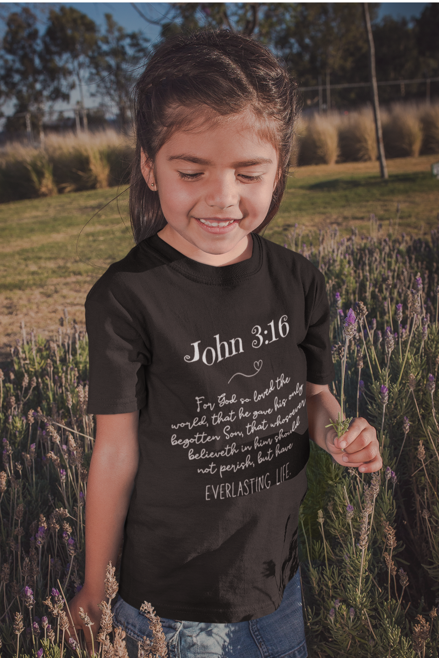 Little girl wearing Kid's Christian Shirt Black with John 3:16 Bible Verse KJV print design. Crew neck, short-sleeved, classic fit