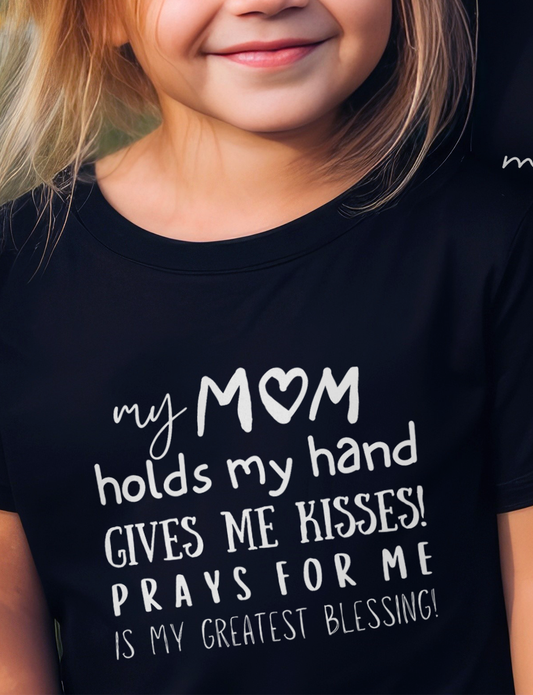 Kid's Mother's day Black T-shirt with "My Mom holds my hand, gives me kisses, prays for me, is my greatest blessing" print design. Crew neck, short-sleeved, classic fit