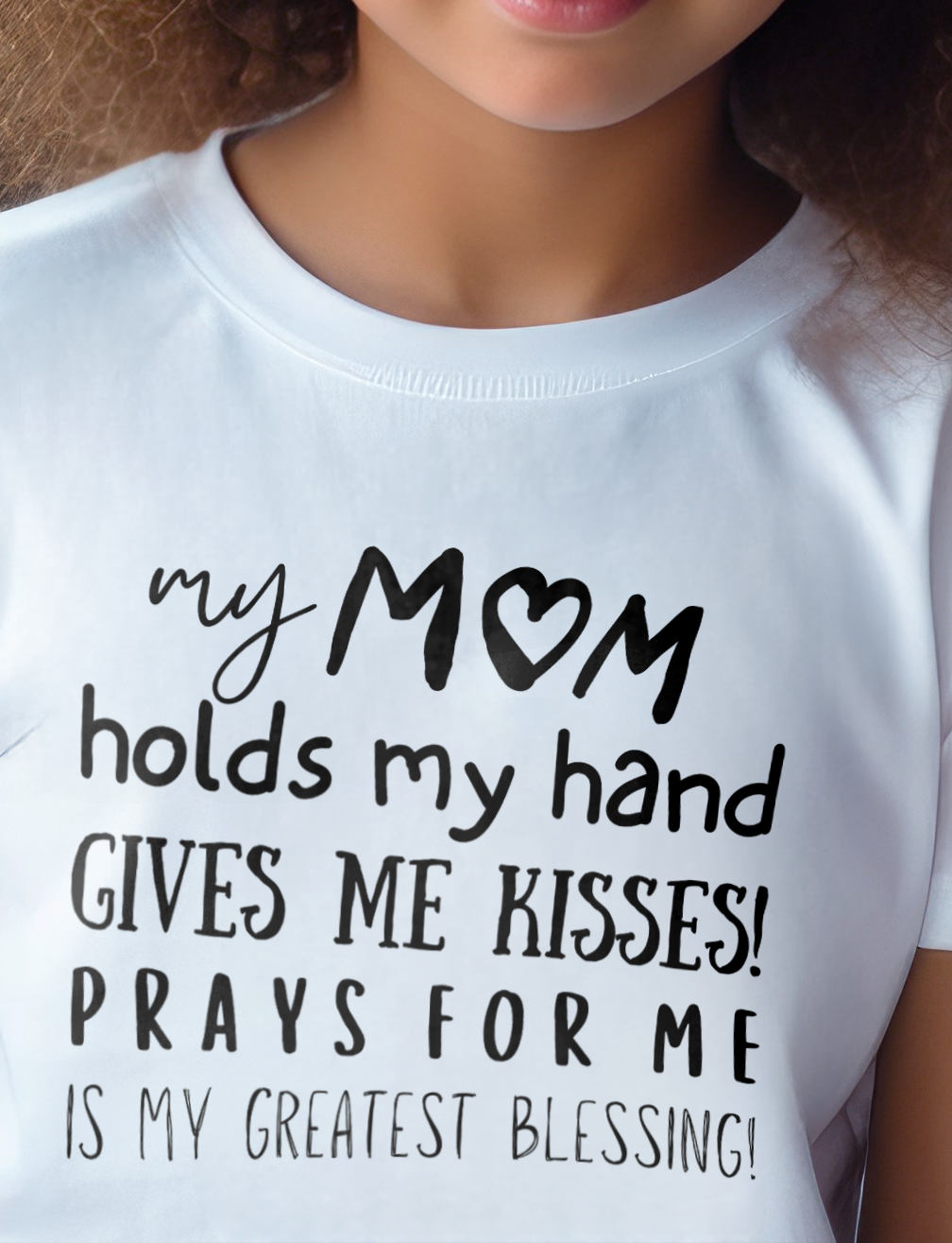 White Kid's Mother's day T-shirt with "My Mom holds my hand, gives me kisses, prays for me, is my greatest blessing" print design. Crew neck, short-sleeved, classic fit