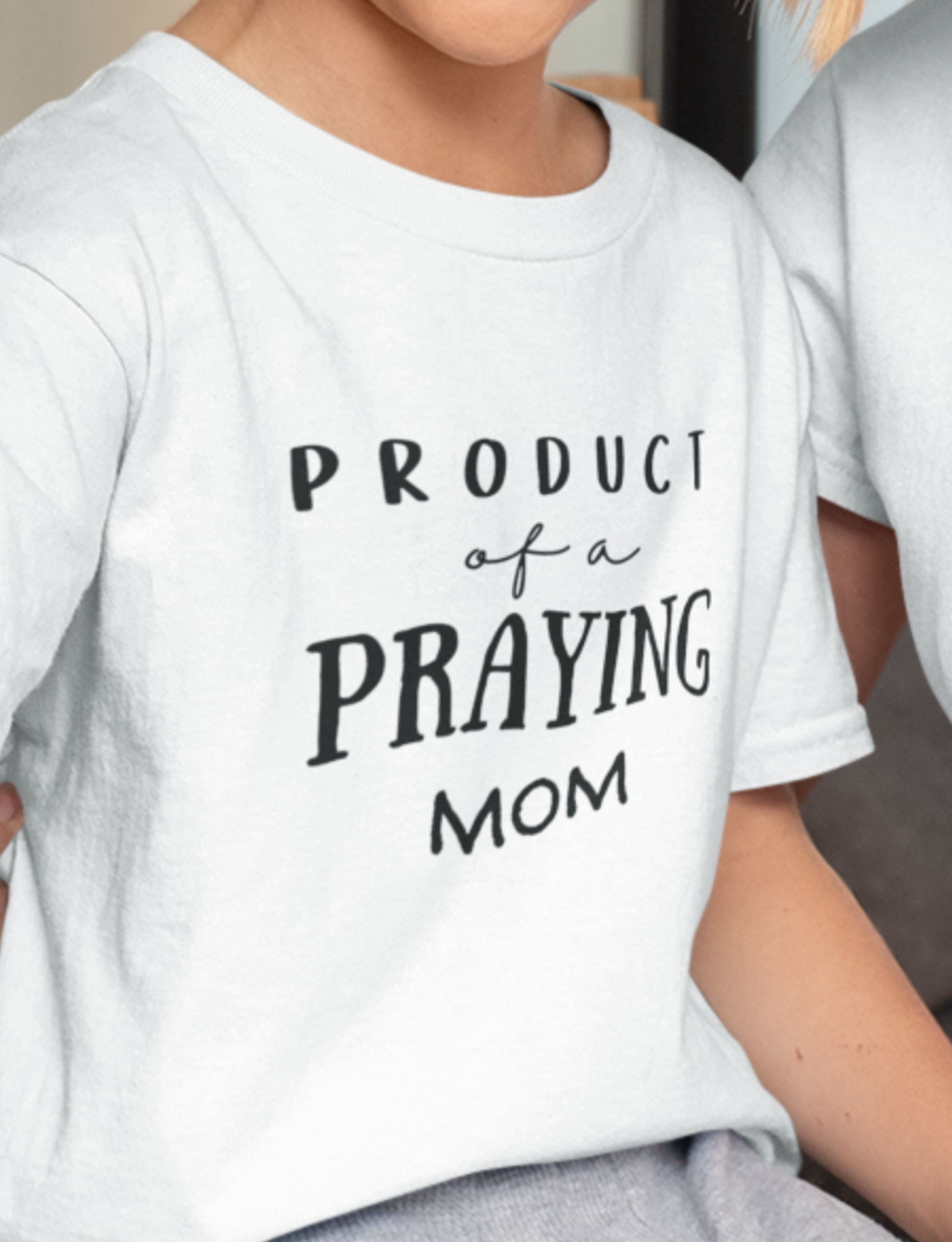 White Kid's Mother's Day T-Shirt with "Product of a Praying Mom" print design. Crew neck, short-sleeved, classic fit