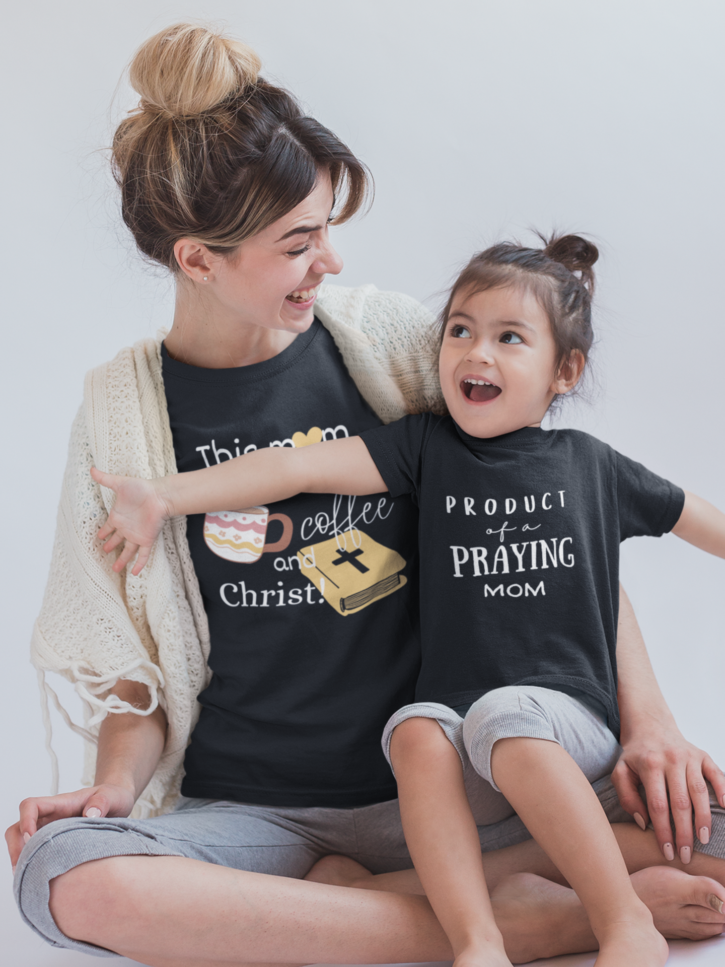 Black Kid's Mother's Day T-Shirt with "Product of a Praying Mom" print design. Crew neck, short-sleeved, classic fit